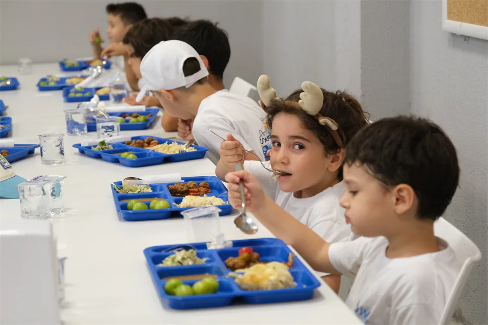 AquaWave yaz okulunda aynı masada öğle yemeği yiyen çocuklar