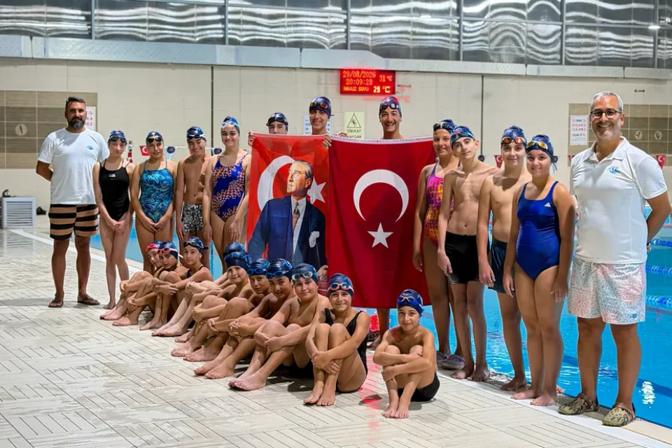 AquaWave Antalya yüzme takımı sporcuları ve antrenörleri Türk bayraklarıyla havuz başında